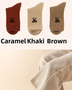 Detail of wool-blend knit socks in earth tones featuring embroidered S6 and ribbed texture