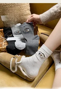 Detail of colorful speckled knit socks with cute three bears embroidery and soft ribbing