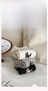 Detailed close-up of ribbed cotton socks with puppy embroidery and red stripe accents
