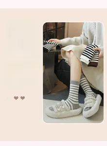Detail of warm striped knit socks in grey and beige paired with plush indoor slippers
