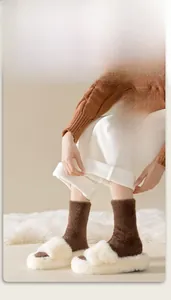 Detailed close-up of thick mink velvet thermal socks paired with plush white slippers