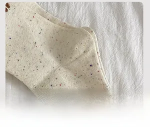 Detailed macro view of reinforced heel stitching on speckled cotton crew socks