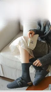 Detail of wool socks showing the bow embroidery and elastic rib cuff for warmth