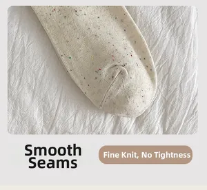 Detailed close-up of the flat toe seam and fine knit texture on cream cotton socks