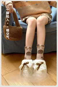 Gros plan de chaussettes épaisses en polaire corail avec motif ours et pantoufles