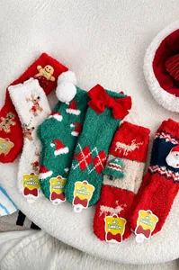 Detail of Christmas coral fleece socks with festive 3D patterns on soft plush background