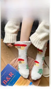 Close-up of fluffy winter socks with festive house patterns and high-elastic ribbed cuffs