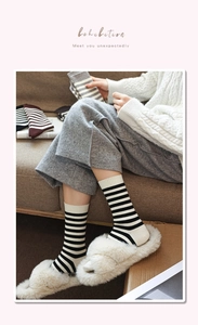 Close-up of striped cotton socks with vertical rib cuffs in a cozy home setting