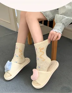 Detail of plush coral fleece socks and slippers with colorful star cloud embroidery