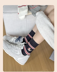 Close-up of knitted mid-calf socks with puppy embroidery and stripes on grey fabric