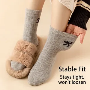 Thick wool socks for women featuring vertical knit texture and black bow embroidery