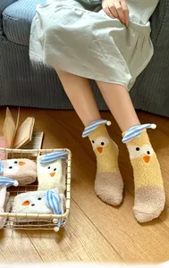 Close-up of thick coral fleece socks with yellow cartoon chick pattern and blue stripes