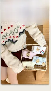 Detailed texture of thick coral fleece socks in pink and blue with cartoon embroidery