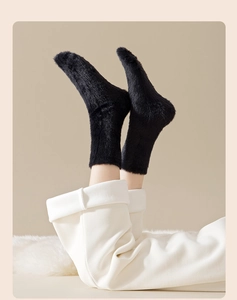 Close-up of soft black faux mink fur thermal socks with thick plush texture for winter