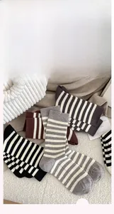 Detail of colorful striped cotton socks with ribbed cuffs in a soft home setting view