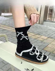 Dettaglio calzini in ciniglia con fiocchi glitterati e sandali platform con bordo in pelliccia