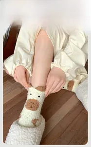 Détail de chaussettes en molleton corail à motif vache avec oreilles en 3D