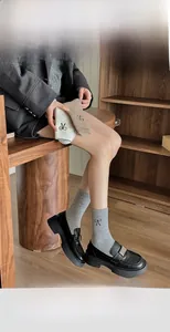 Detail of wool socks with bow embroidery styled with loafers for a preppy look