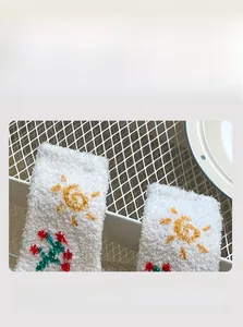 Detail of high-elasticity cuff on white coral fleece socks with floral sun pattern