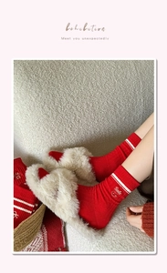 Detail showing red cotton socks with smile embroidery and white stripes in home setting