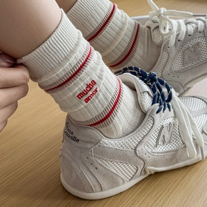 Retro striped crew socks featuring red 'mucho amor' embroidery and knit cotton texture