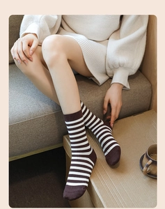 Detail of warm striped crew socks showing soft knit texture and brown stripes on model