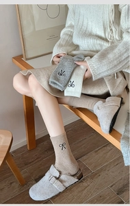 Detailed close-up of ribbed wool blend socks with cute bow embroidery in lifestyle setting