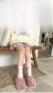 Detailed view of pink coral fleece socks and plush slippers for winter home warmth