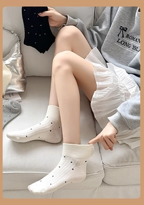 Detail of ribbed cotton socks with black polka dots in white, black and grey colors