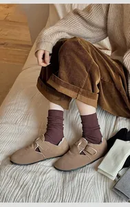 Detailed view of warm purple ribbed knit socks paired with brown suede buckle loafers