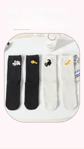 Detailed close-up of cartoon cat and food embroidery on flecked cotton mid-calf socks