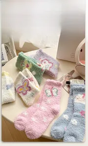 Detailed view of warm coral fleece socks featuring cute knitted butterfly and floral patterns