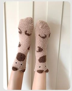 Détail de chaussettes en polaire corail avec oreilles d'ours et motif à pois