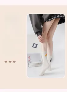 Detail of cream cotton crew socks with cute cartoon embroidery and flecked yarn texture
