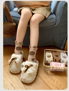 Gros plan de chaussettes en polaire corail avec oreilles 3D et pantoufles douces