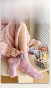 Detail of high-elastic pink coral fleece socks with star patterns and green bows