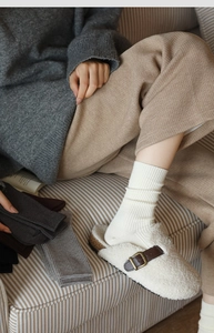 Close-up of thick ribbed knit texture on warm winter crew socks in neutral grey and beige
