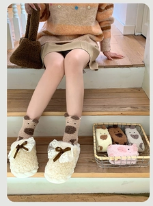 Détail de chaussettes en molleton de corail et chaussons en peluche avec jolis nœuds