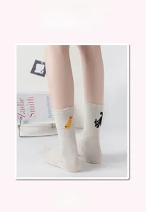 Detail of cream cotton socks with cat embroidery and colorful flecked knit fabric