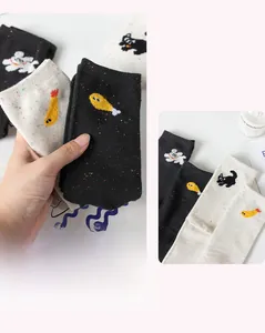 Detailed knit of cotton crew socks with colorful speckles and cute cartoon embroidery