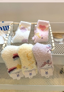 Detail of soft coral fleece socks in pastel colors with heart and star patterns