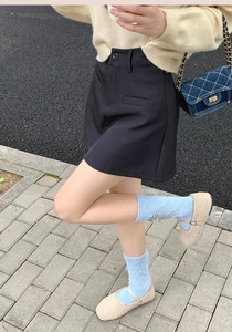 Dettaglio calzini in ciniglia azzurro con scarpe basse di peluche beige per l'inverno