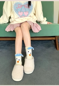Close-up of thick coral fleece winter socks with cute cartoon chick and blue stripes