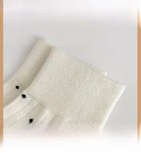 Close-up of white cotton blend socks with black polka dots and elastic ribbed cuffs