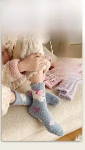 Detail of thick coral fleece winter socks in blue with soft pink floral patterns