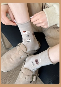 Détail de chaussettes en coton avoine avec broderies d'animaux mignons et bordure côtelée