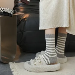 Grey and white striped warm crew socks styled with metallic buckle fur slippers
