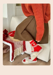 Detailed view of red cotton socks with white stripes and smile embroidery with plush slippers