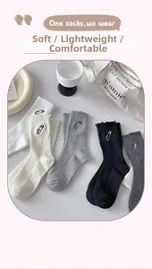 Detailed flat lay of cotton crew socks with distressed frayed edges and pin embroidery