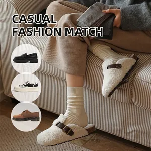 Thick ribbed knit winter socks in off-white paired with fleece slippers and buckle detail
